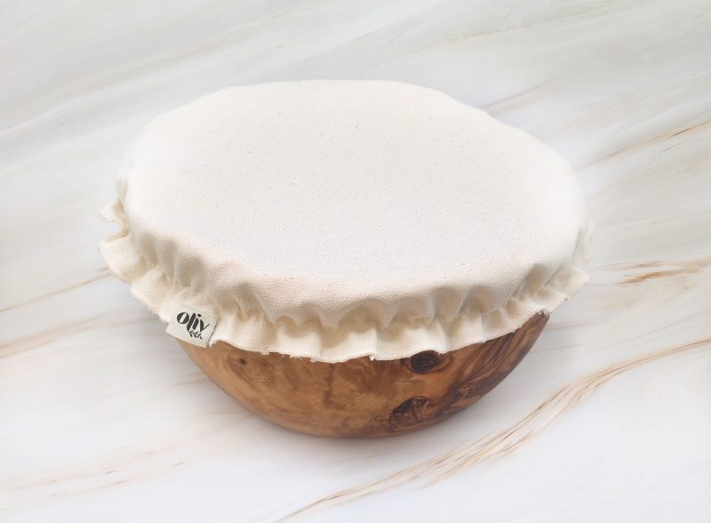 Organic cotton bowl cover fitted over a handcrafted olive wood bowl